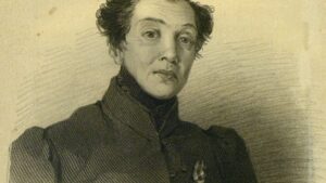 Androgynous person aged perhaps mid 30s, wearing high collar tweed dress coat