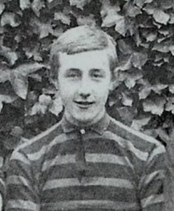 Head and shoulders photo of a smiling boy aged about 13, wearing a striped rugby shirt